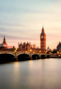 Scenic view of Big Ben and Westminster Bridge over the Thames River at sunset in London, UK.